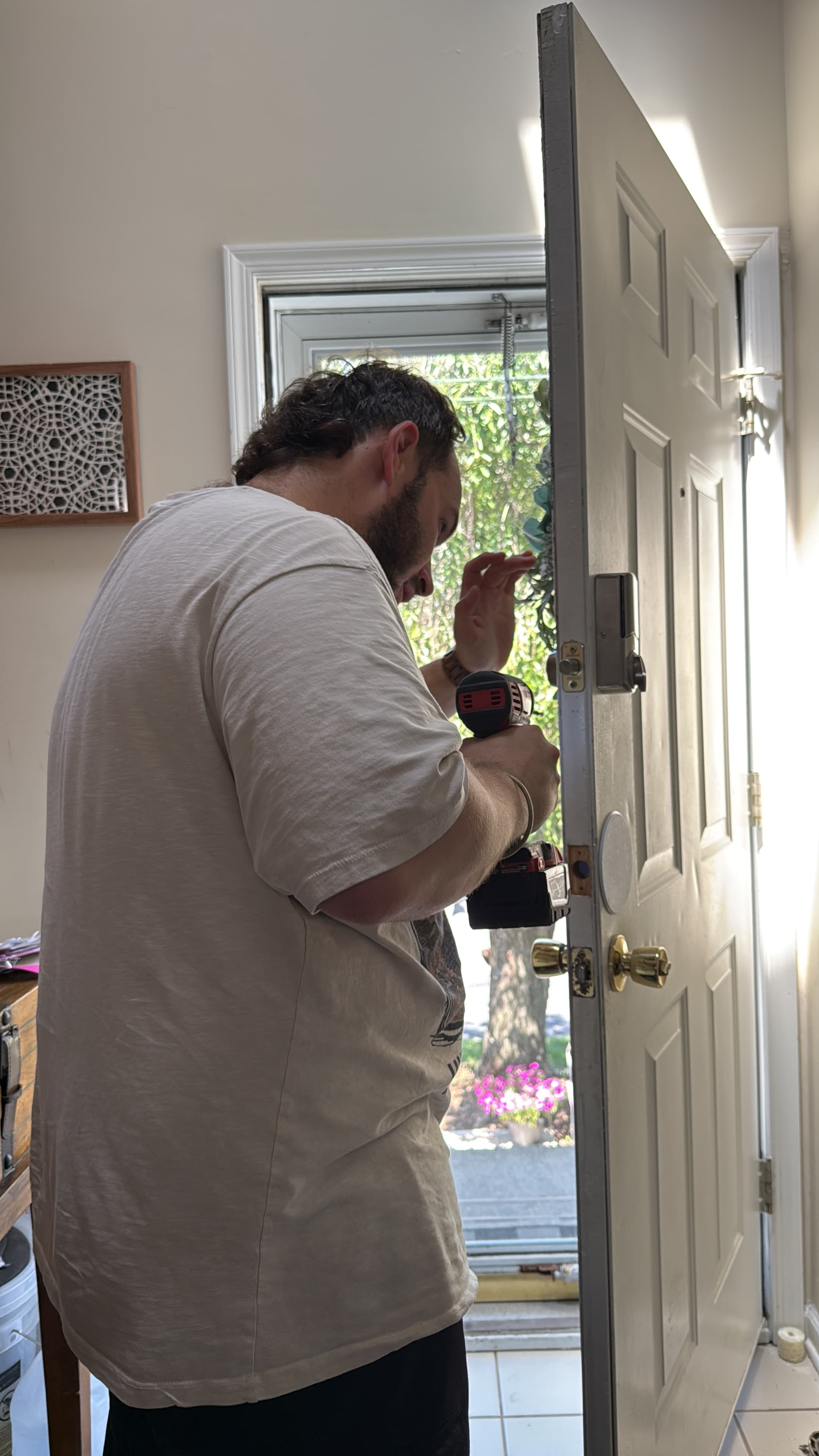Amit Mager installing a new lock with a power drill